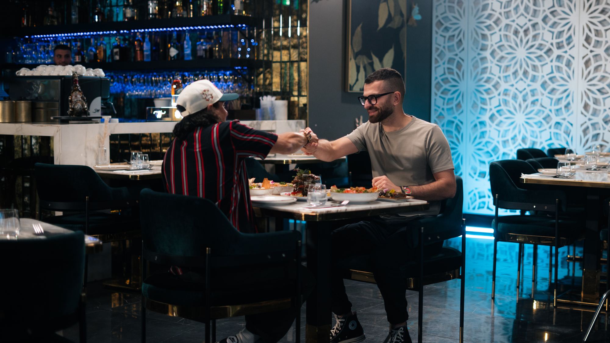 Emile Khoury partage un repas avec un invité pendant un tournage de Lunch Sérieux